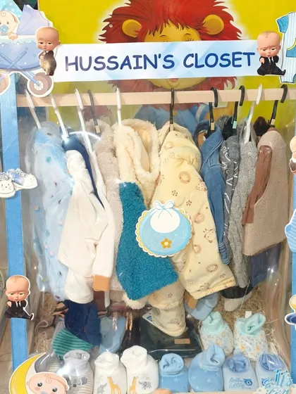 'Hussain's Closet', a Boss Baby themed wardrobe hamper filled with adorable baby clothes and bibs.