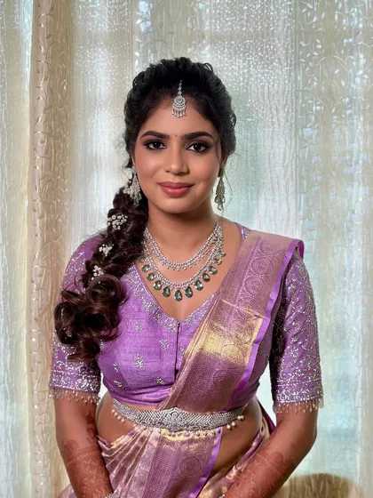 A glamorous engagement look in a lavender saree, with smokey eyes and a beautifully braided hairstyle.