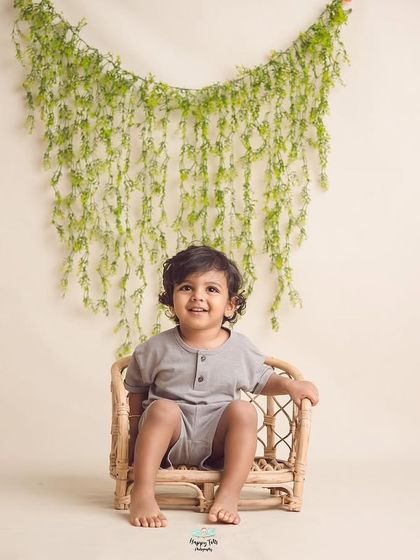 This handsome boy's sweet smile is the only thing that matters here. We use simple, neutral sets to let your child's natural charm shine.