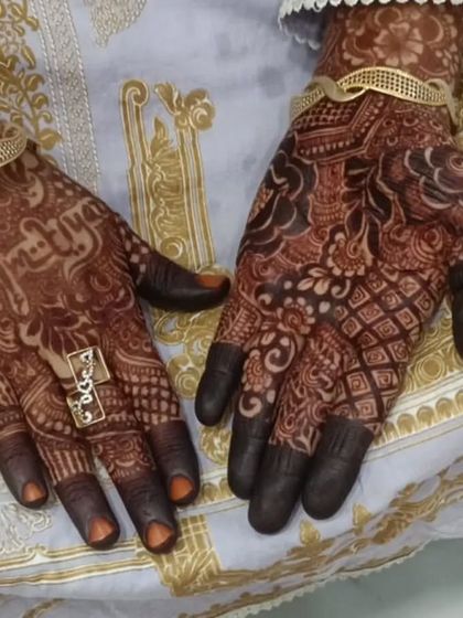 A candid shot of the party mehendi, showing how it complements the client's beautiful outfit and jewelry.