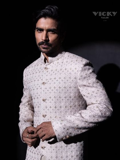 A portrait that captures the essence of our design philosophy. This model wears a heavily embroidered sherwani, showcasing the powerful impact of detailed craftsmanship.