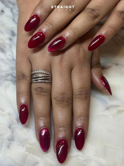 A classic red manicure gets an upgrade with a subtle cat-eye effect. The magnetic shimmer adds a modern twist to a timeless color.