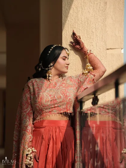 Yashi, my beautiful Haldi bride, basking in the sun. Her look is vibrant and fresh, with a peachy-orange outfit and makeup that gives her a warm, sun-kissed glow.