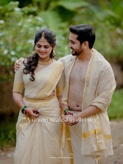 A romantic walking portrait of the couple, their traditional kasavu attire glowing in the soft light.