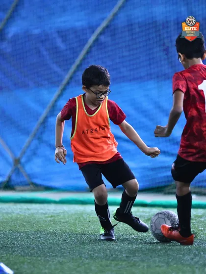 A young player works on his dribbling in a tight space, improving his close control and agility.