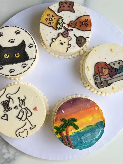 A collection of some of my favorite doodle mini cakes. From a sleepy cat and a sunset scene to a fashion-themed design, these cakes show the endless creative possibilities.