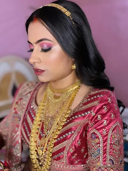 Bride Pooja, looking stunning for her reception. I created a bold look with dramatic pink eyeshadow and a deep lip color to match her vibrant outfit.