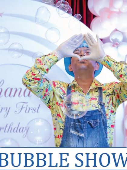A bubble show entertainer making a heart shape with his hands, surrounded by floating bubbles. It's a performance filled with charm and wonder.