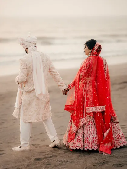 The beginning of a new journey, captured as the couple walks hand in hand along the sandy shore after their wedding.