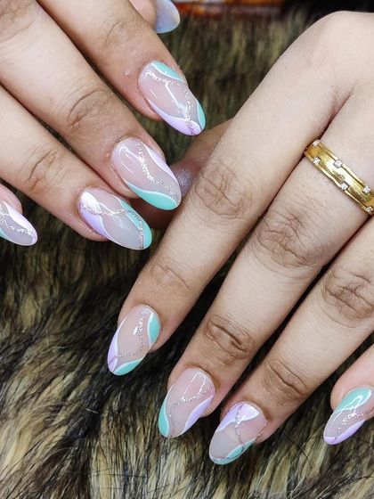 A soft and dreamy abstract design, featuring pastel green and lilac swirls with a touch of silver glitter on almond-shaped nails.