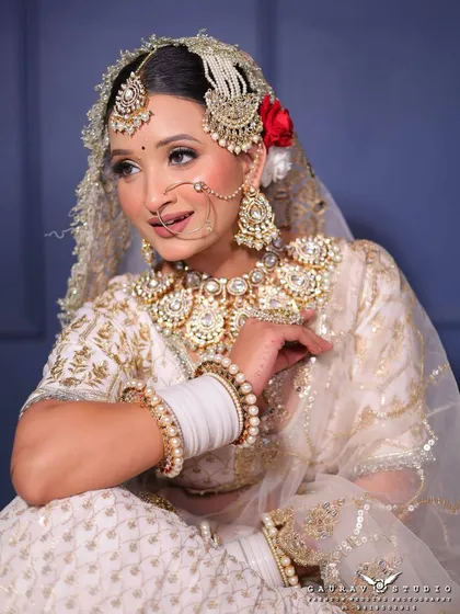 Who says a bride has to wear red? This elegant white and gold lehenga is for the modern bride who wants a royal and sophisticated look. The detailed embroidery and matching jewellery create a complete set.