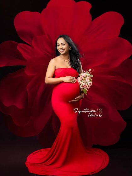 A smiling portrait in a red gown with a floral fabric effect, creating a unique and artistic look.