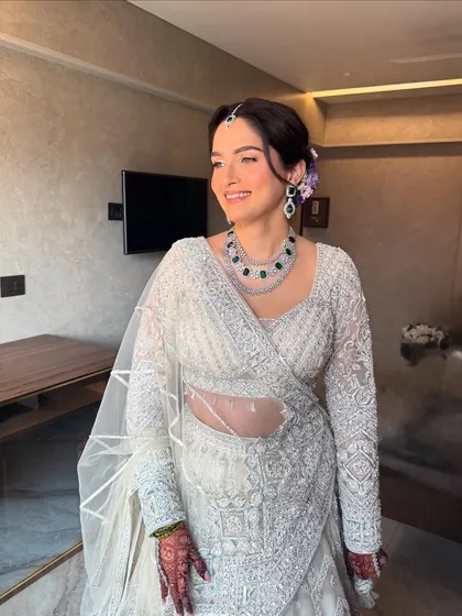 A full-length view of this elegant ivory reception look. The makeup is timeless, ensuring she looks graceful and beautiful throughout her celebration.