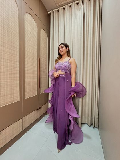 This purple ruffled saree is a modern take on festive wear. The embellished blouse adds glamour, while the pre-draped style is perfect for a hassle-free, high-fashion look.