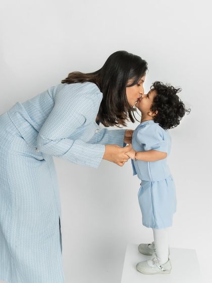 A mother's kiss is one of the sweetest moments to photograph. This candid shot captures a tender interaction, preserving a memory of pure affection between mother and daughter.