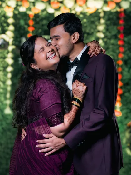 Unfiltered happiness! This candid shot of a groom's affectionate kiss and his bride's joyful laughter is exactly the kind of authentic moment we strive to preserve.