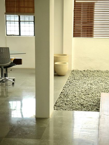 A quiet corner in the Zanav Home Studio, where polished stone floors meet a bed of pebbles. The design juxtaposes different natural textures to create visual and tactile interest.