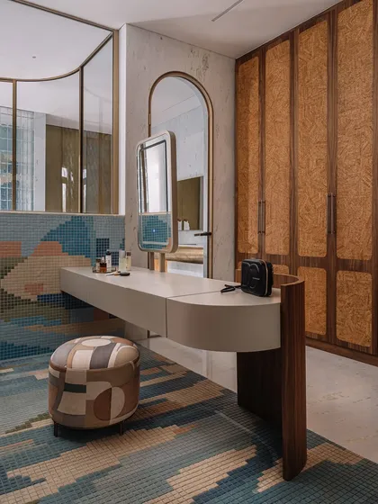 In this master bathroom, we collaborated with our partners to create a stunning mosaic tile rug that mimics the patterns on the wall. The space also features a brass-clad linen closet with custom marble handles, adding a layer of warmth and opulence.