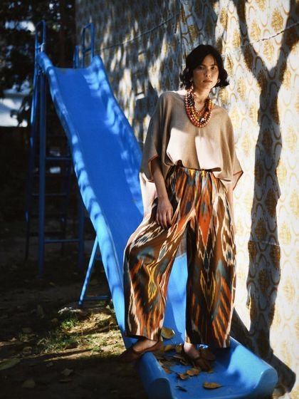 A playful and unexpected shot on a slide. This image brings a sense of fun and nostalgia to fashion, showing that style doesn't have to be serious.