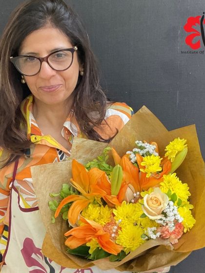 This elegant hand-tied bouquet features orange lilies and chrysanthemums. Our students learn not just how to arrange, but also how to wrap their creations for gifting and sale.