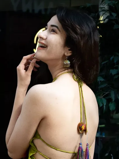 A joyful, candid shot showing the back of the unique green top. It's important to capture all the details that make an outfit special.