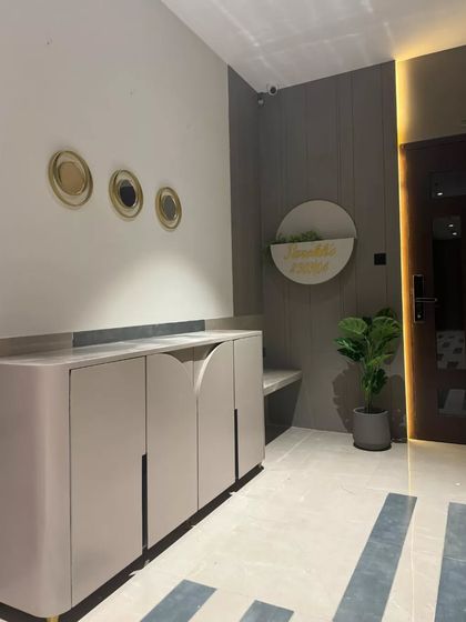 Another view of our modern and minimalist entrance. The design features a sleek veneer door, soft grey panel walls, and a custom nameplate, radiating an upscale, calming vibe that sets the tone for a stylish home.