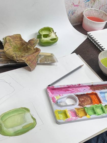This workstation view shows the setup for painting a capsicum. You can see the real object, the initial sketch, and the palette with mixed greens, showing our hands-on process.
