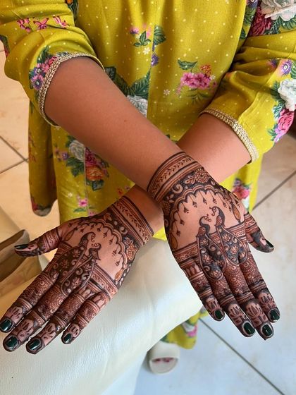 The peacock mehendi looks beautiful with the client's festive yellow outfit.