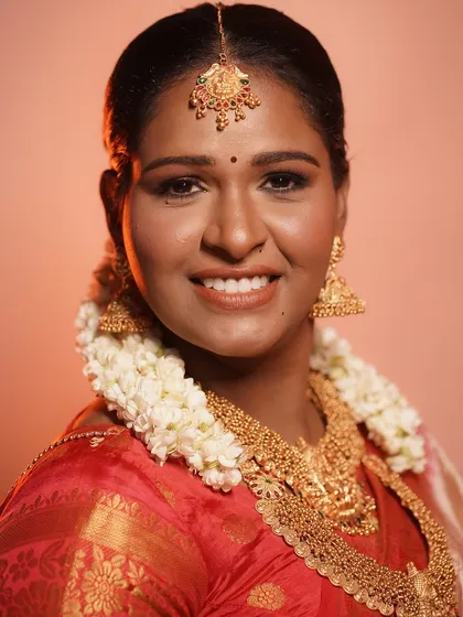 A joyful shot of the bride, her smile radiating as much as her skin. The makeup is designed to look stunning both in person and in photographs.