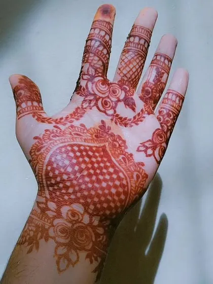 A lovely example of a romantic henna design. The central heart is filled with a 'jaali' or net pattern, and the surrounding floral vines have stained to a beautiful deep red.