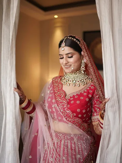 A vision in red. This bride looks absolutely radiant, framed by the curtains, ready for her big moment.