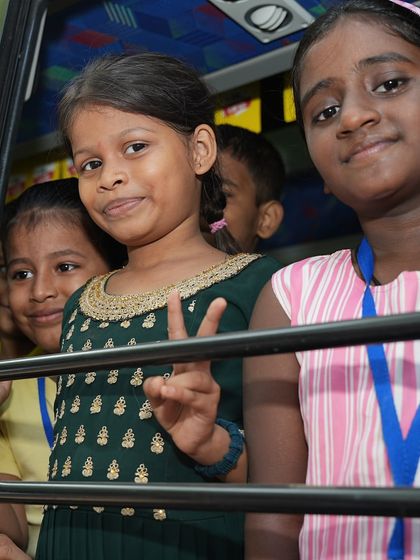 The bright, happy faces of children looking out from the 'Sound Space on Wheels' bus. This vehicle represents a window to a new world of creativity and learning for them.