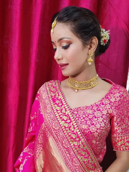 For this traditional look, I focused on creating sharp, defined eyes with winged liner and soft pink tones on the lips to complement the vibrant Banarasi lehenga. The hair is styled in a classic bun, adorned with fresh flowers for an authentic festive feel.