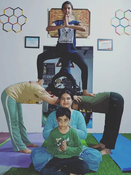 A full family acro yoga pose. We have a seated base, two supporting pillars, and a flyer on top. It's a wonderful way to connect and create something memorable as a group.