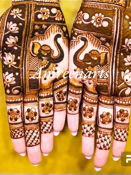 A close-up of fingers and palms adorned with elephant motifs and floral details.