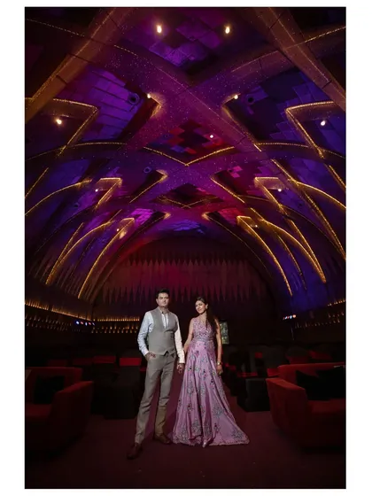 A stunning portrait of a couple in a venue with dramatic, arched ceilings and purple lighting. This shot highlights the grandeur of the location.