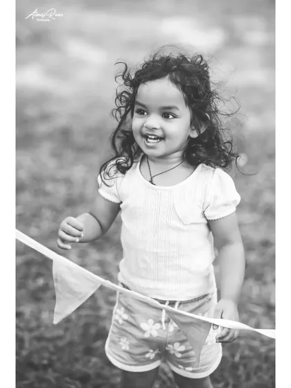 The joy of movement captured in a candid black and white photo. Riona's happy expression and windswept hair are the focus of this playful shot from her second birthday session.