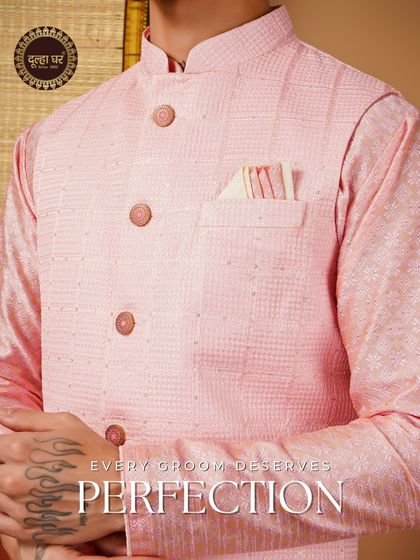 Every groom deserves perfection. A close-up on a pink textured Nehru jacket, highlighting the button and pocket square details.
