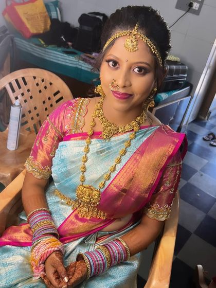 My beautiful bride Inchara, ready for her ceremony. We chose a stunning light blue and pink Kanjivaram saree and paired it with traditional gold jewelry.