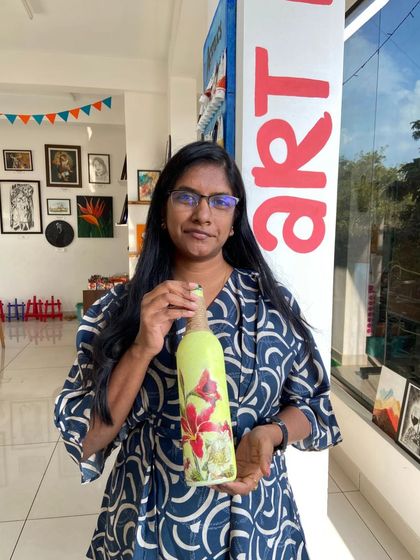 A participant with her finished decoupage bottle. The workshop teaches you how to seamlessly blend the paper cutouts with the painted surface.