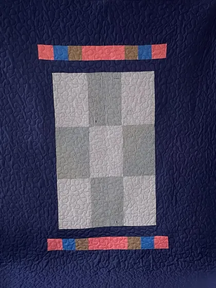 The back of a memory quilt made from shirts, featuring a simple yet elegant design.