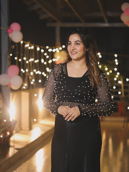 The right lighting can make an outfit sparkle. Here, the fairy lights highlight the delicate pearl work on the top, creating a magical and festive atmosphere.