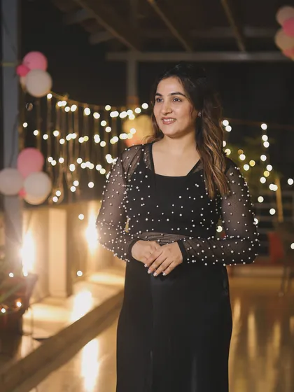 The right lighting can make an outfit sparkle. Here, the fairy lights highlight the delicate pearl work on the top, creating a magical and festive atmosphere.