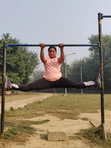 Holding a middle split on a pull up bar. This variation adds an element of upper body strength to the intense lower body stretch.