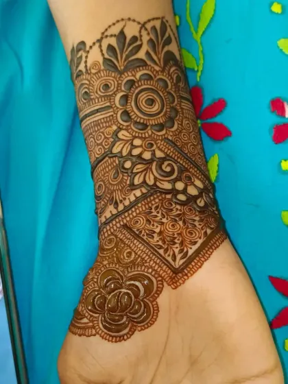 A close-up of the wrist detail, showing the combination of floral and geometric elements.