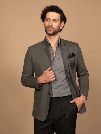 A classic grey bandhgala jacket with a detailed crest embroidered on the pocket. It’s a versatile piece that can be dressed up or down.