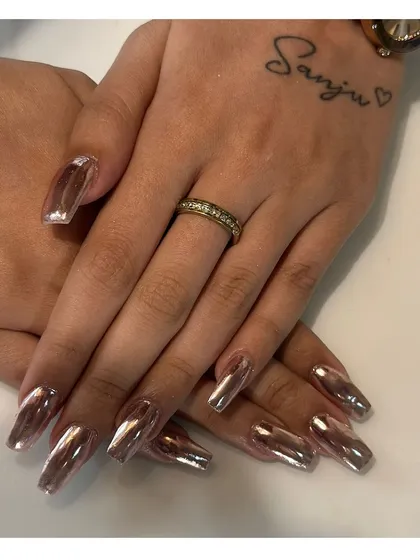 Make a bold statement with our chrome nail extensions. This set showcases a flawless, mirror-like rose gold chrome finish on long, square-shaped nails for a futuristic and trendy look.