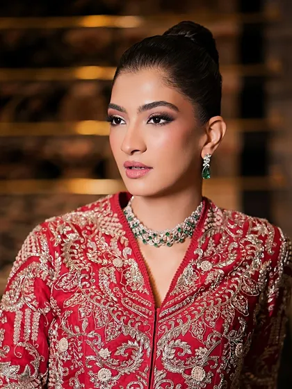 A close-up of the sophisticated makeup look. The skin is flawless and matte, and the eyes are subtly defined to create a chic and polished aesthetic.