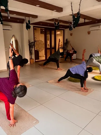 A class moves through a powerful side-angle pose, their synchronized forms creating a beautiful visual.