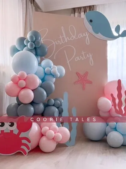 An adorable under-the-sea adventure for a little one's birthday. This minimal yet charming setup includes cute crab and whale cutouts with a simple balloon arrangement in soft pinks and blues.